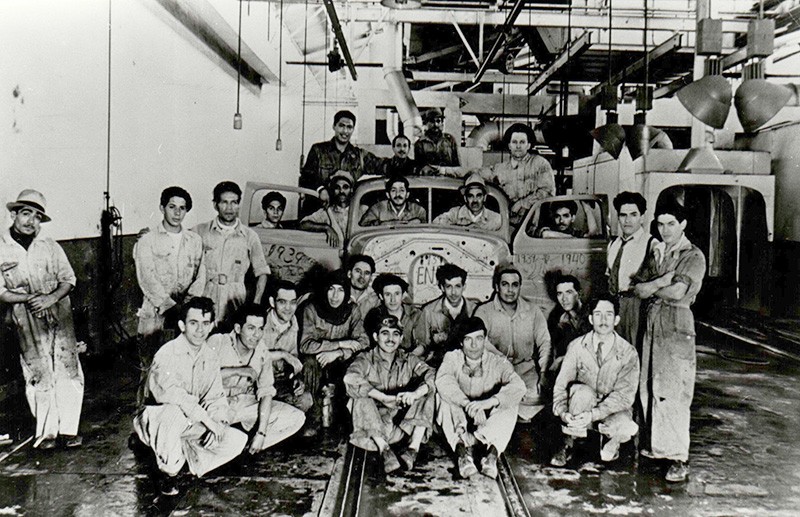 Trabajadores posan junto a vehículo en proceso, tras apertura de planta de GM en México.